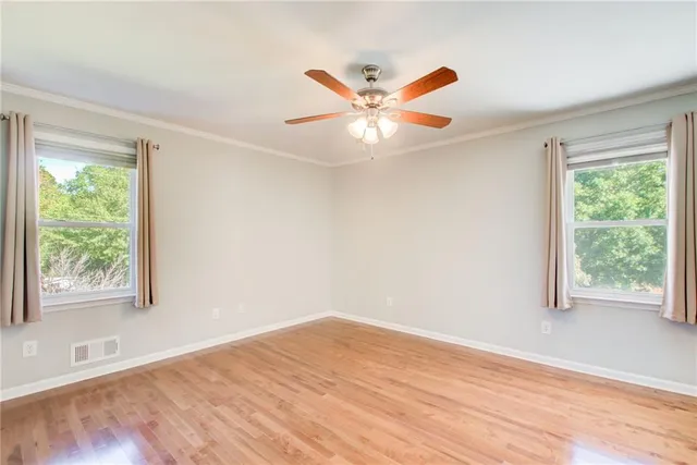 a view of a patio with table and chairs under an umbrella with large trees