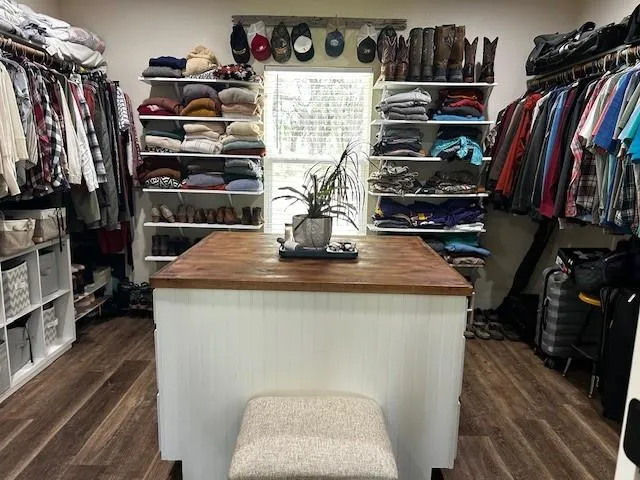 a view of walk in closet with clothes and shoes