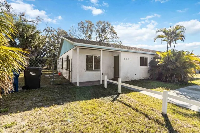 a white house that has a tree in front of it