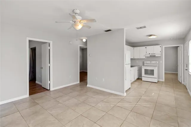 an empty room with kitchen and fireplace
