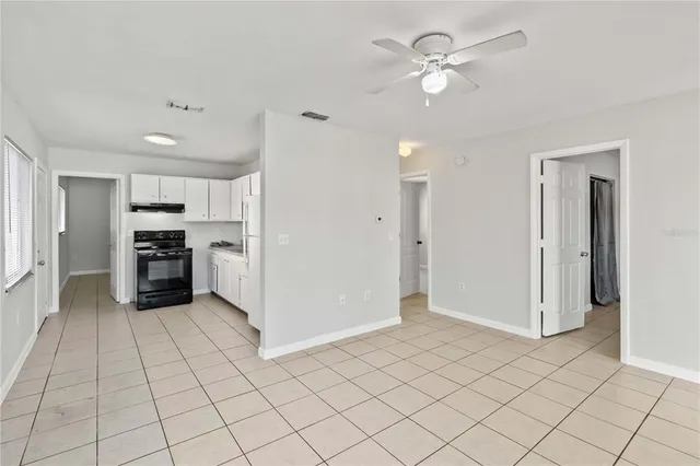 a kitchen with granite countertop a refrigerator and a stove top oven