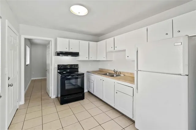 a kitchen with white cabinets and white appliances