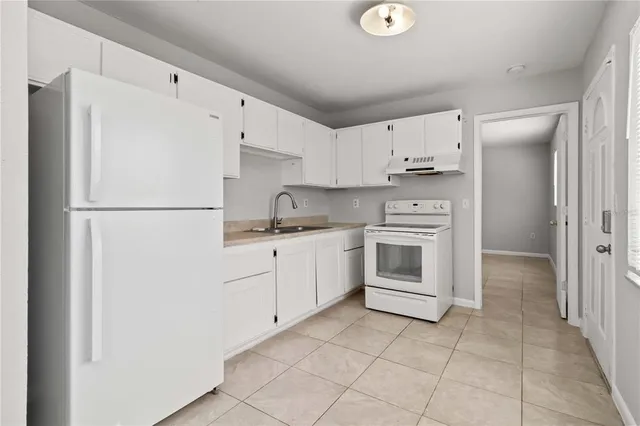 a kitchen with stainless steel appliances a refrigerator sink and cabinets