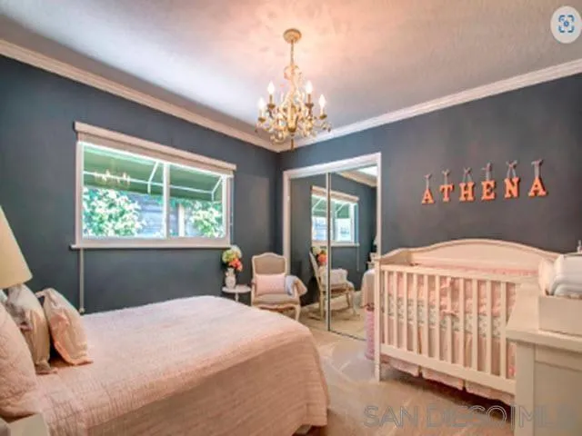 5512 Candlelight Drive La Jolla, CA 92037 - Photo 18 of 23 a bedroom with a bed and a chandelier