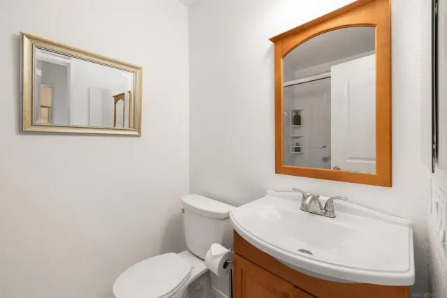 a bathroom with a toilet a sink and mirror