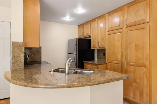 a kitchen with stainless steel appliances granite countertop a sink a stove and a refrigerator