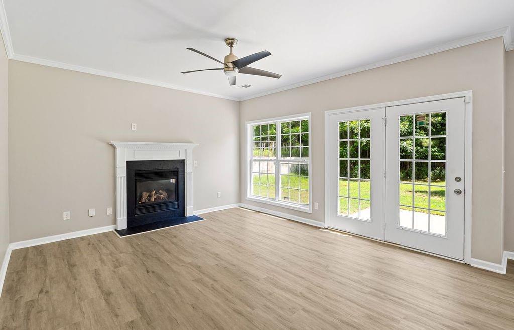 473 Greyhawk Way Fairburn, GA 30213 - Photo 13 of 34 an empty room with windows fireplace and a ceiling fan