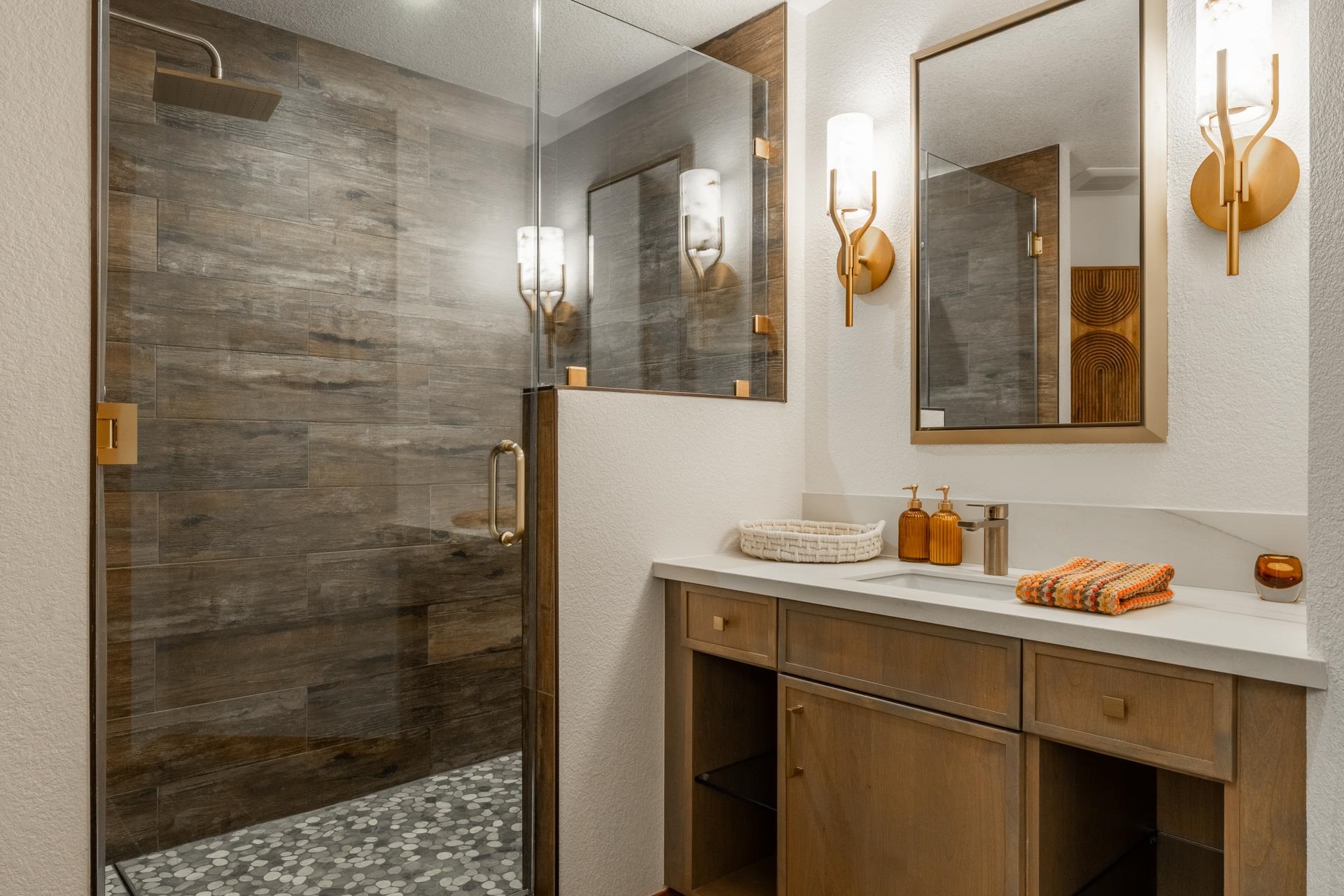 6201 Minaret Road, Unit 2430 Mammoth Lakes, CA 93546 - Photo 33 of 54 Walk-in shower featuring a frameless glass enclosure, wood-finish tile walls, pebble flooring, and a
