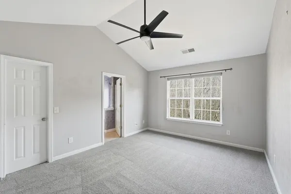 a view of a livingroom with a ceiling fan and windows
