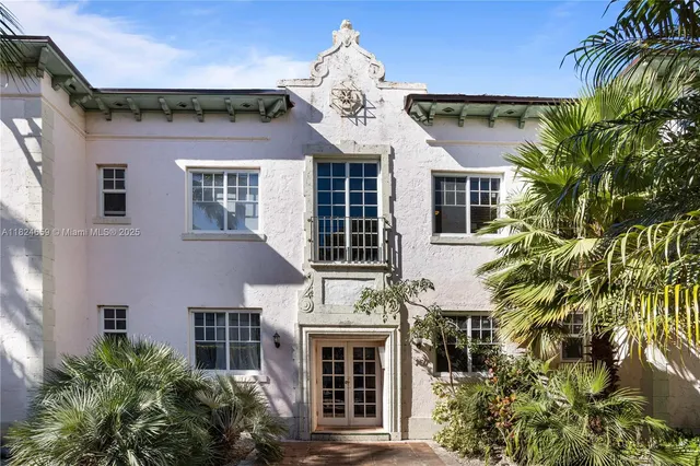front view of a house with a palm tree
