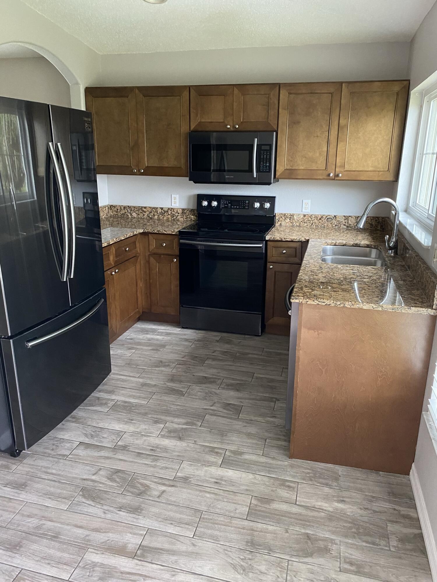 2836 Osprey Cove Place, Unit 201 Kissimmee, FL 34746 - Photo 2 of 11 a kitchen with a refrigerator sink and stove