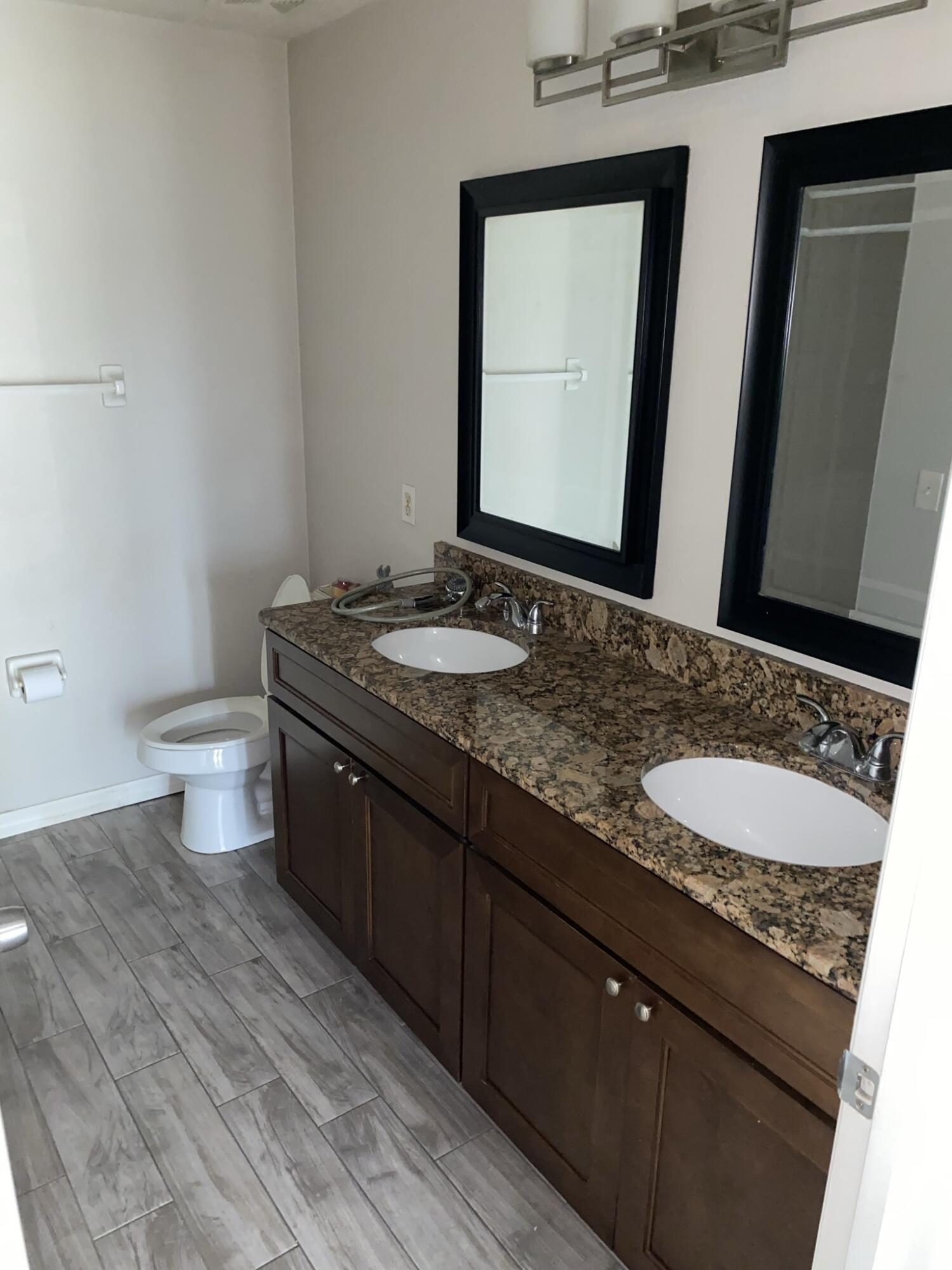 2836 Osprey Cove Place, Unit 201 Kissimmee, FL 34746 - Photo 3 of 11 a bathroom with a granite countertop sink and a mirror