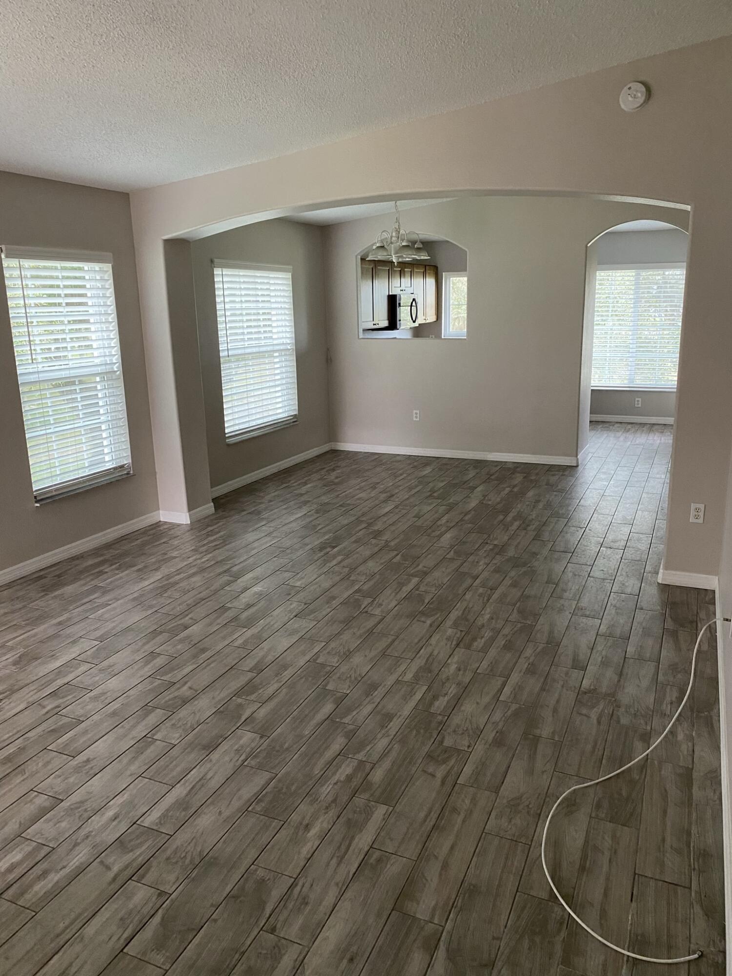 2836 Osprey Cove Place, Unit 201 Kissimmee, FL 34746 - Photo 5 of 11 a view of an empty room with wooden floor and a window