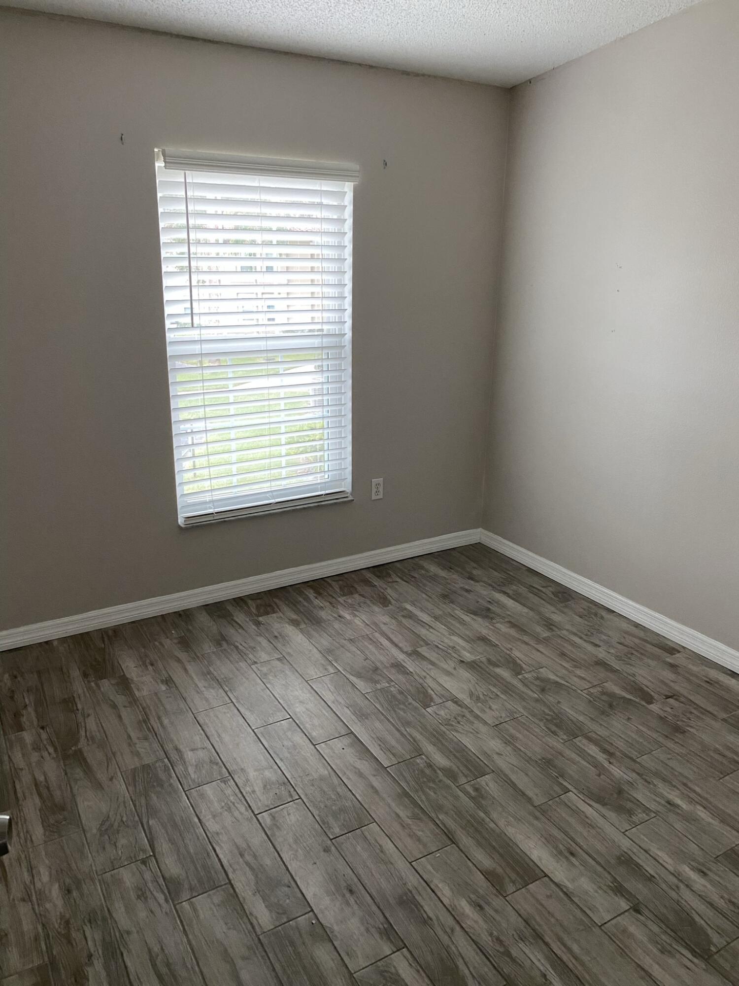 2836 Osprey Cove Place, Unit 201 Kissimmee, FL 34746 - Photo 6 of 11 a view of an empty room with wooden floor and a window
