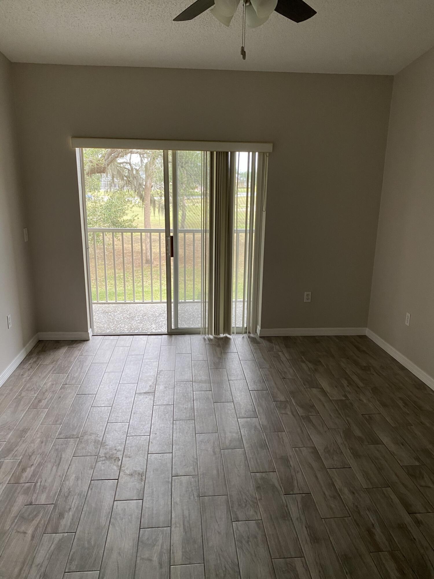 2836 Osprey Cove Place, Unit 201 Kissimmee, FL 34746 - Photo 7 of 11 wooden floor in an empty room with a window