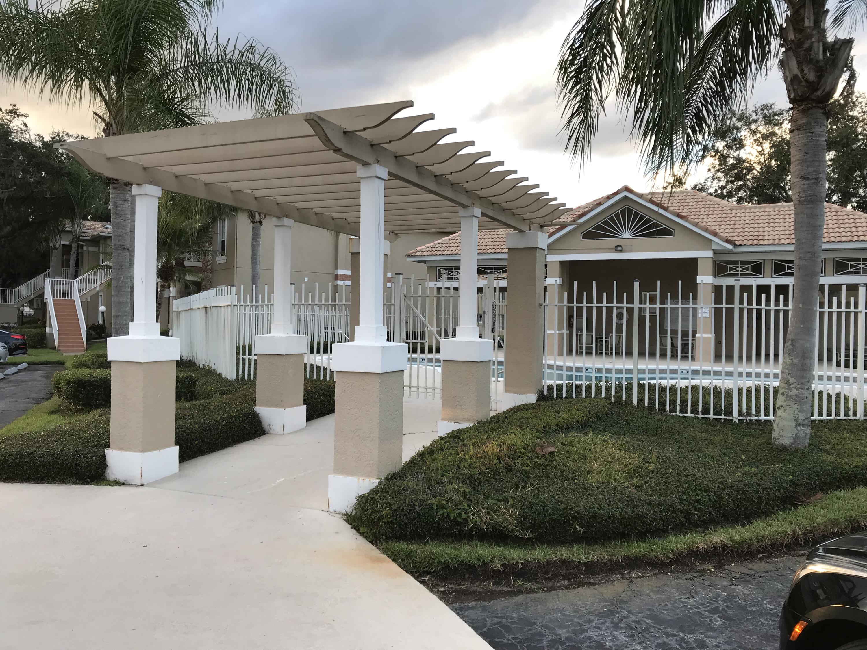2836 Osprey Cove Place, Unit 201 Kissimmee, FL 34746 - Photo 10 of 11 a view of a house with a small yard and plants