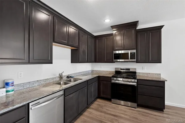a kitchen with stainless steel appliances granite countertop a sink stove microwave and cabinets
