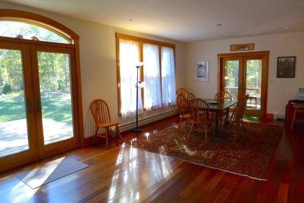 267 Great Plains Road West Tisbury, MA 02568 - Photo 7 of 34 a dining room with wooden floor and a floor to ceiling window