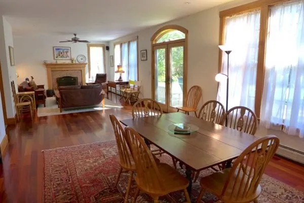 a view of a a dining room with furniture window and wooden floor