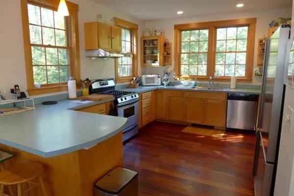 a kitchen with stainless steel appliances granite countertop a sink a stove and a refrigerator