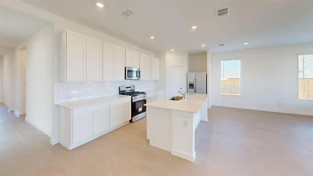 a kitchen with white cabinets and white appliances