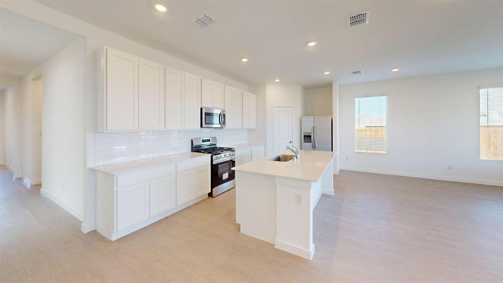 454 Ridge Drive Justin, TX 76247 - Photo 5 of 24 a kitchen with white cabinets and white appliances