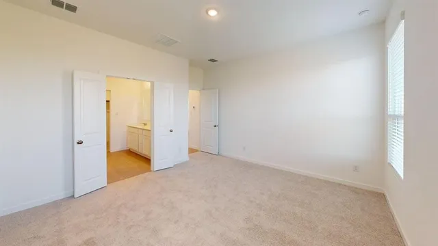 an empty room with closet and a bathroom