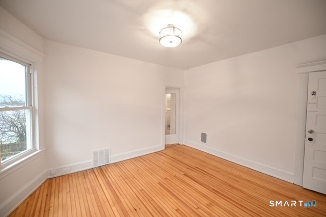 117 Marion Street, Unit 2 Bridgeport, CT 06606 - Photo 1 of 1 a view of empty room with wooden floor and fan