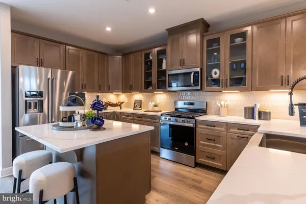 a kitchen with stainless steel appliances granite countertop a stove refrigerator sink and cabinets