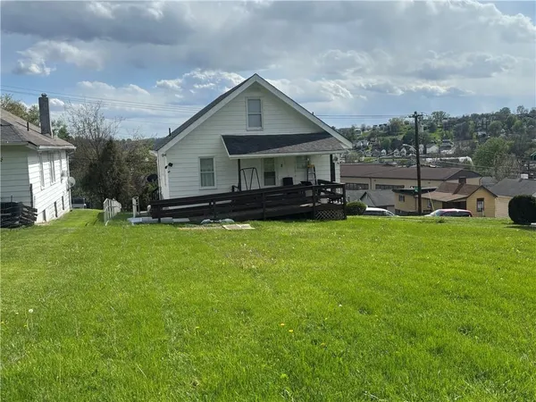 a view of a house with a yard and sitting area