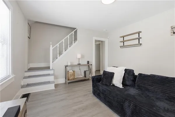 a living room with furniture and a wooden floor