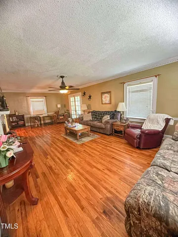 a living room with furniture kitchen view and a window