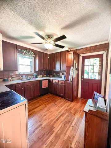 a large kitchen with stainless steel appliances wooden floors and a refrigerator