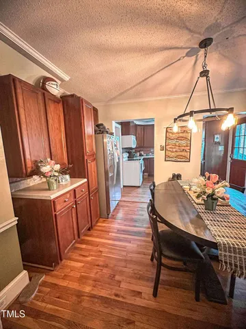 a kitchen with a table chairs and refrigerator