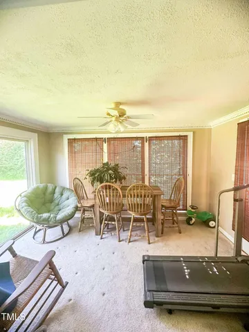 a dining room with furniture and a large window