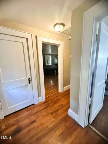 a view of a hallway with wooden floor and closet