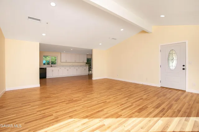 a view of a kitchen and an empty room