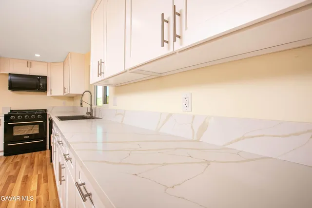 a kitchen with a sink cabinets and a stove top oven