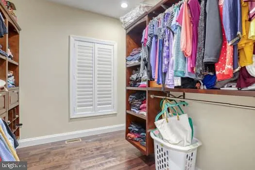 a bedroom with a large bed a flat tv screen and dresser