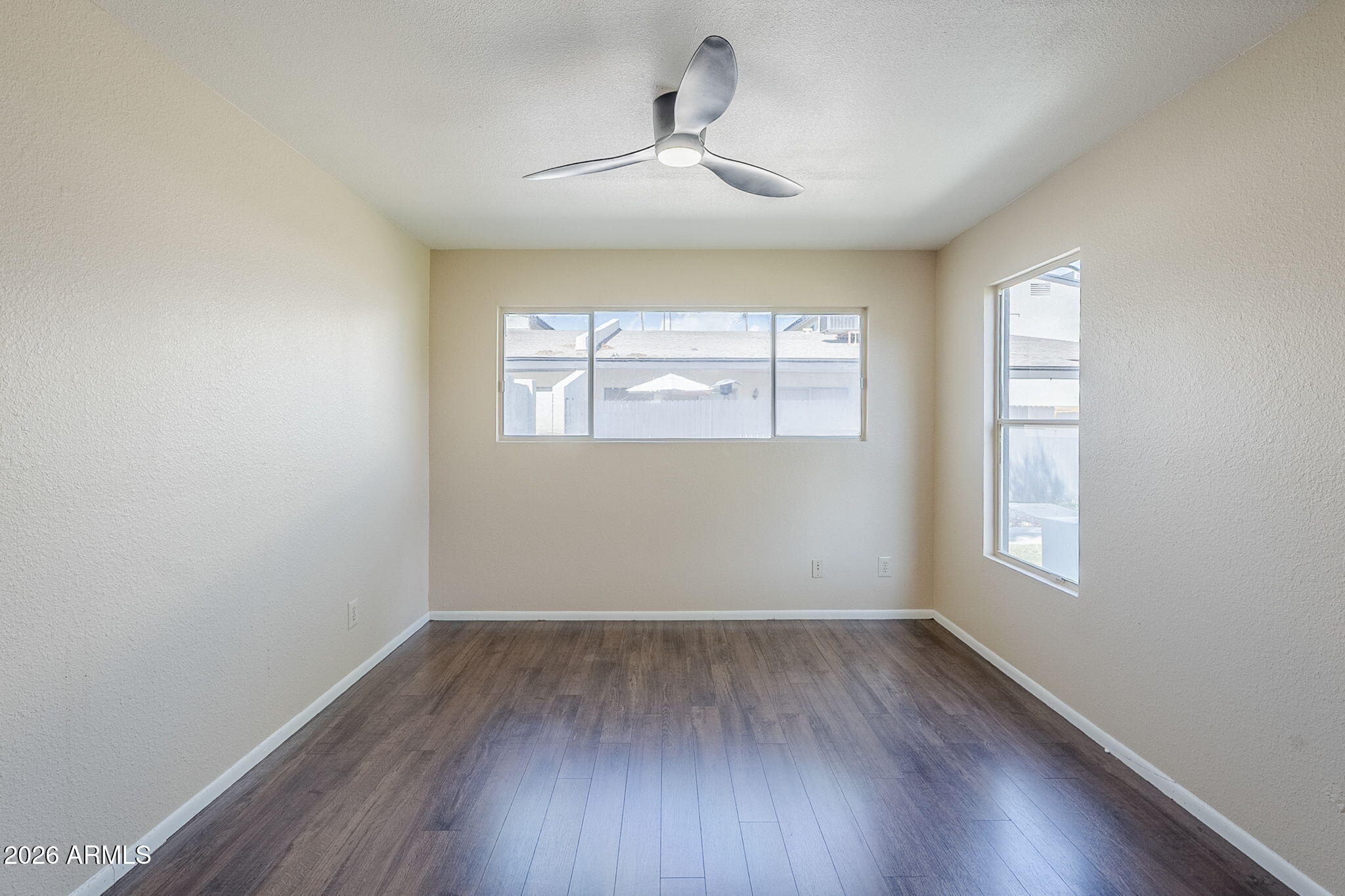 1051 South Dobson Road, Unit 128 Mesa, AZ 85202 - Photo 20 of 30 an empty room with wooden floor chandelier and windows