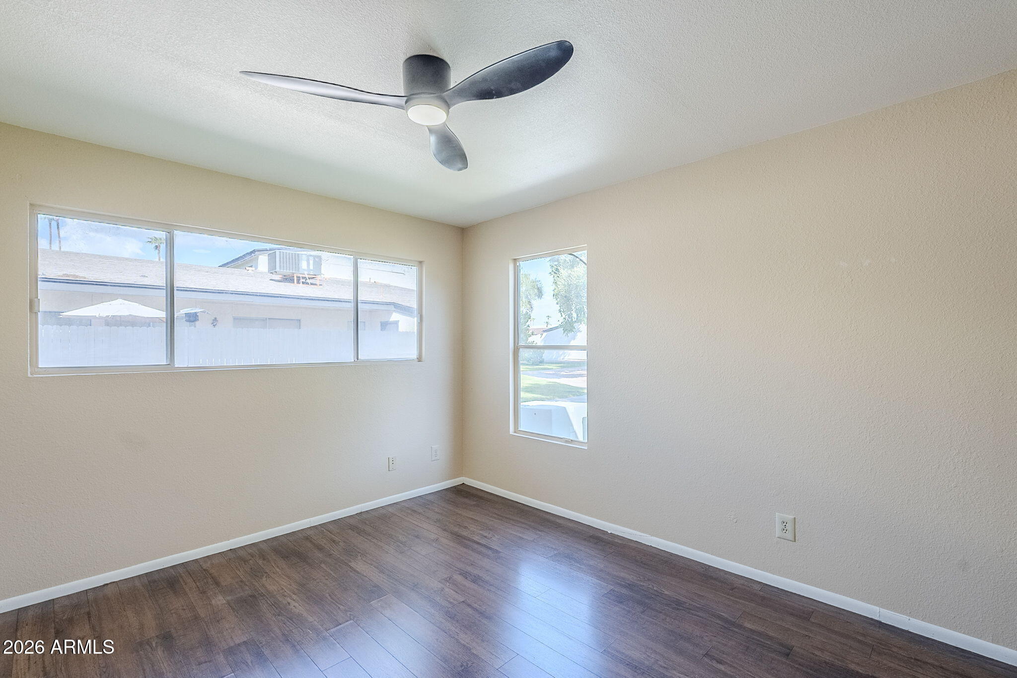 1051 South Dobson Road, Unit 128 Mesa, AZ 85202 - Photo 21 of 30 an empty room with wooden floor chandelier fan and windows