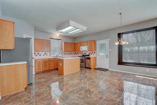 a large kitchen with kitchen island a sink stainless steel appliances and cabinets
