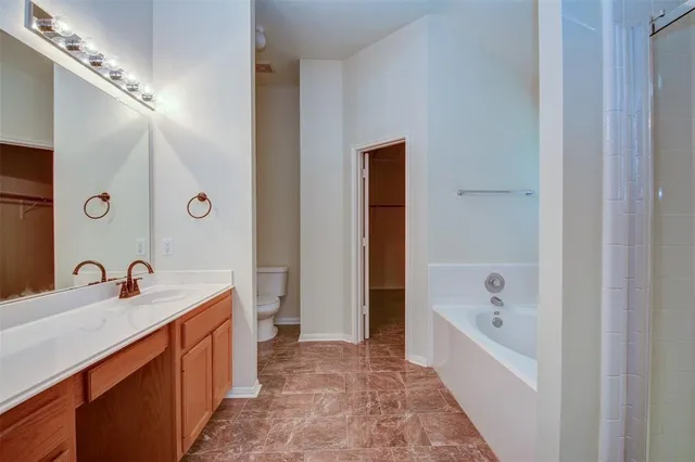 a bathroom with a tub sink and mirror