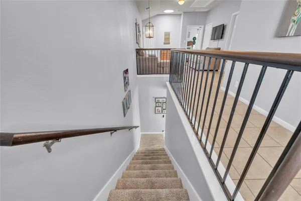 a view of a hallway with wooden floor and stairs