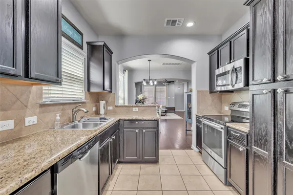 a kitchen with stainless steel appliances granite countertop a sink stove and cabinets