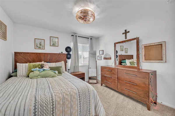 a bedroom with a large bed and a chandelier