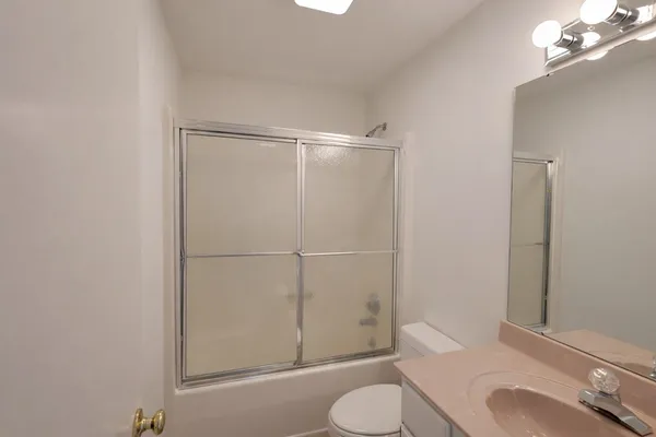 an empty room with a window and a ceiling fan