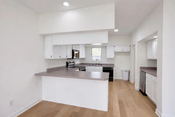 a kitchen with stainless steel appliances white cabinets and sink