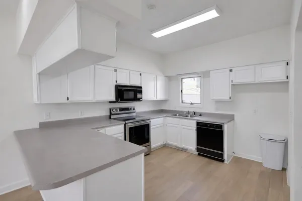 a kitchen with cabinets stainless steel appliances and sink