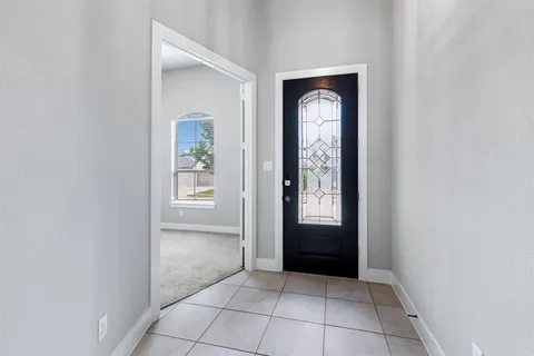 an empty room with windows and mirror